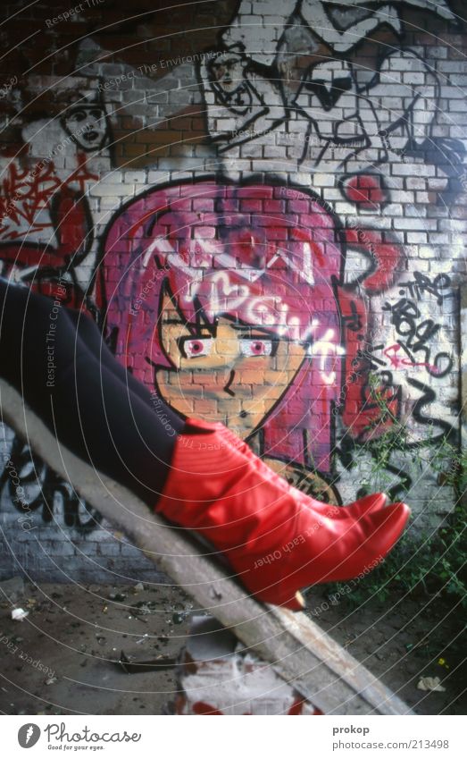 Rote Stiefel mit Gesicht Lifestyle Mensch feminin Junge Frau Jugendliche Erwachsene Mauer Wand Mode liegen Coolness Glück rebellisch schön Lebensfreude bizarr
