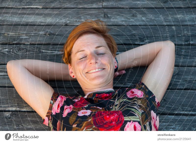 Am See - junge Frau liegt lächelnd in der Abendsonne auf einem Holzsteg Wellness harmonisch Wohlgefühl Zufriedenheit Erholung Ferien & Urlaub & Reisen Sommer