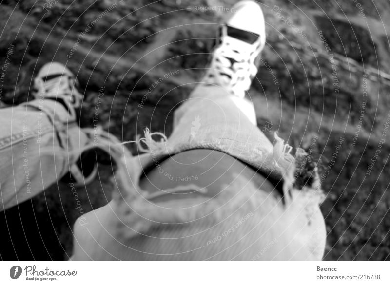 Hangover Mensch Jugendliche Beine Fuß 1 Mode Hose Jeanshose Turnschuh Erholung sitzen Pause Steinboden Schuhbänder Loch Stofffaser Schwarzweißfoto Außenaufnahme