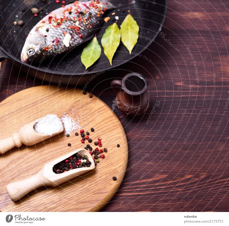 Fischkarpfen in einer schwarzen Bratpfanne Meeresfrüchte Kräuter & Gewürze Pfanne Löffel Küche Holz frisch braun Karpfen Lebensmittel Salz Paprika
