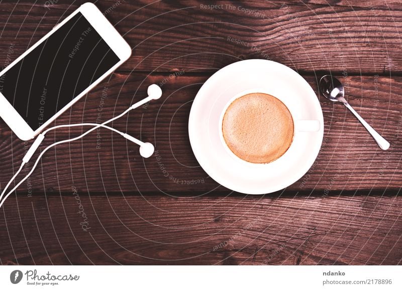weiße Tasse mit Kaffee und Schaum Frühstück Getränk Espresso Tisch Restaurant Telefon PDA Bildschirm Holz heiß natürlich braun schwarz Farbe Cappuccino