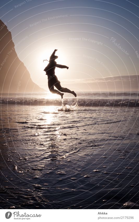 Junge Frau springt aus dem Meer in den Sonnenuntergang Leben harmonisch Zufriedenheit Sinnesorgane Abenteuer Tanzen Jugendliche Natur Wolkenloser Himmel