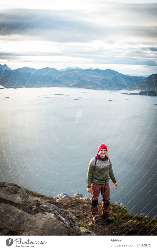 Junge Frau steht auf einer Klippe über den Lofoten Ferien & Urlaub & Reisen Abenteuer Ferne Freiheit wandern Jugendliche Landschaft Fjord Meer authentisch