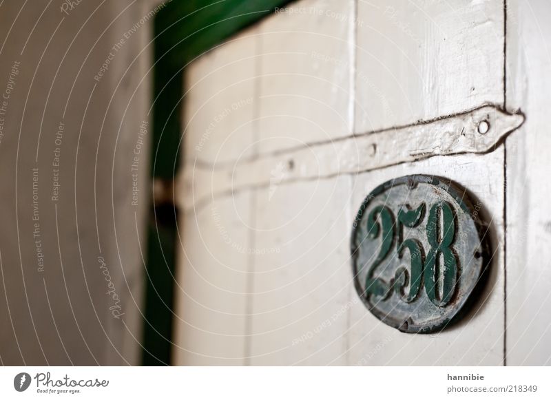 258 Tür Holz Metall alt dreckig grün weiß gestrichen Holztür Hausnummer staubig vergessen Einsamkeit altmodisch lackiert Farbfoto Innenaufnahme Menschenleer