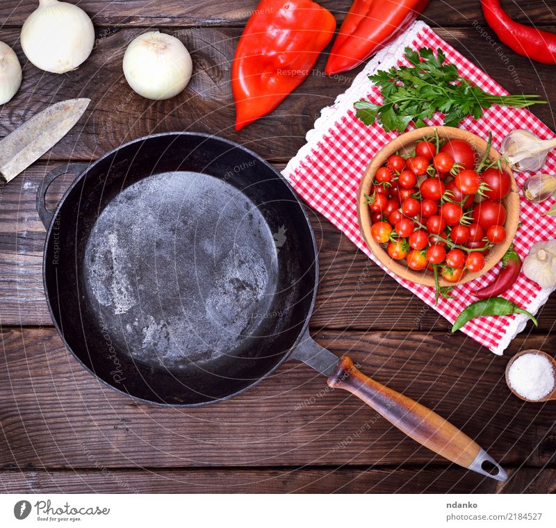 leere schwarze Gusseisenbratpfanne Lebensmittel Gemüse Ernährung Essen Pfanne Messer Küche Holz braun rot Bratpfanne rund Gußeisen Tomate Zwiebel Salz reif Koch