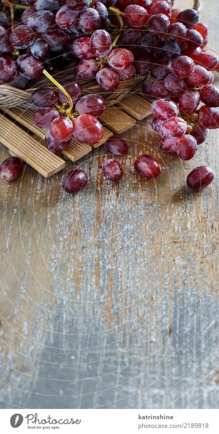 Rote Trauben auf einem alten Holztischabschluß oben Frucht Ernährung Tisch Herbst dunkel frisch retro rot Ackerbau Beeren Lebensmittel Weintrauben Weinrebe