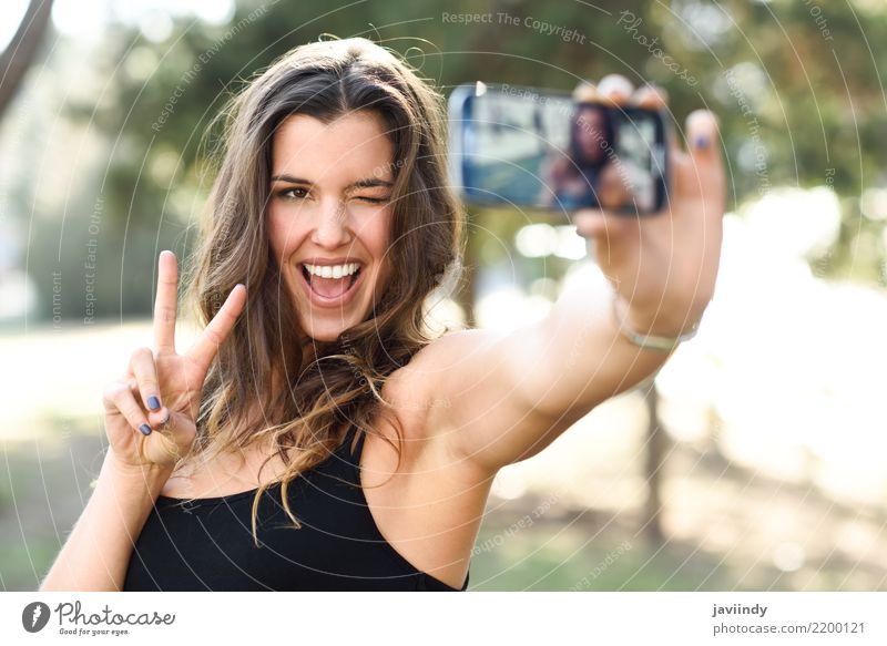 junge Frau Selfie im Park mit einem Smartphone v Zeichen zu tun Freude Glück schön Gesicht Handy Fotokamera Technik & Technologie Mensch Erwachsene Finger