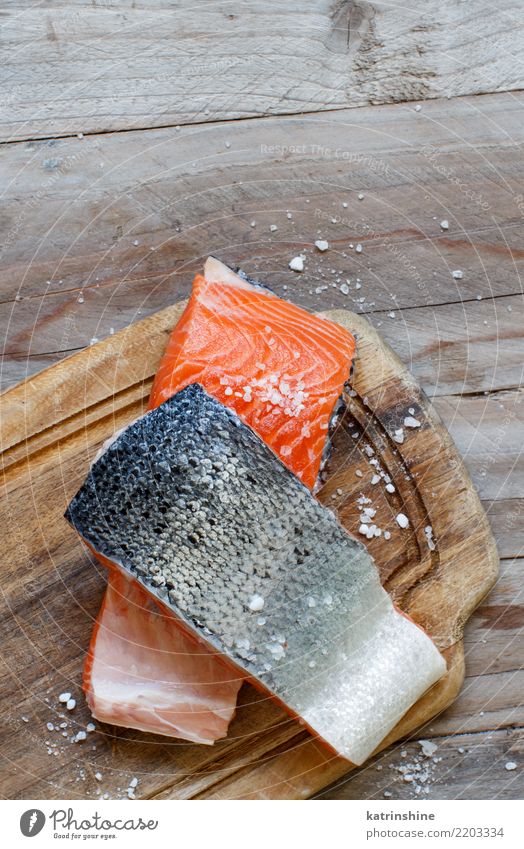 Frische rohe Lachse auf einem hölzernen Schneidebrett Fisch Ernährung Essen Abendessen Diät Tisch frisch oben rot Hintergrund Holzplatte Essen zubereiten