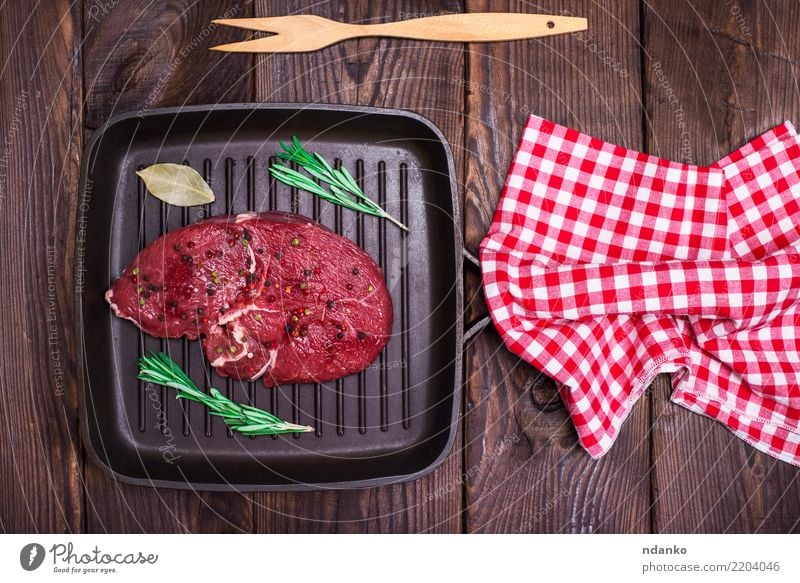 Rindersteak mit Gewürzen Fleisch Kräuter & Gewürze Abendessen Pfanne Tisch Küche Holz Essen frisch oben braun rot schwarz Hintergrund Barbecue Rindfleisch