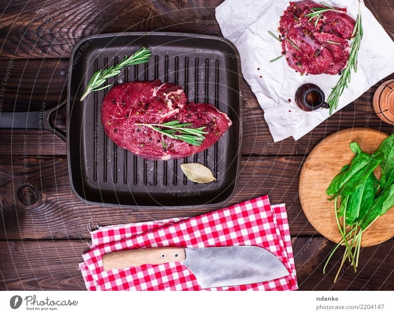 rohes Rindersteak Lebensmittel Fleisch Kräuter & Gewürze Abendessen Pfanne Messer Tisch Küche Papier Holz frisch grün rot Hintergrund Rindfleisch Blut