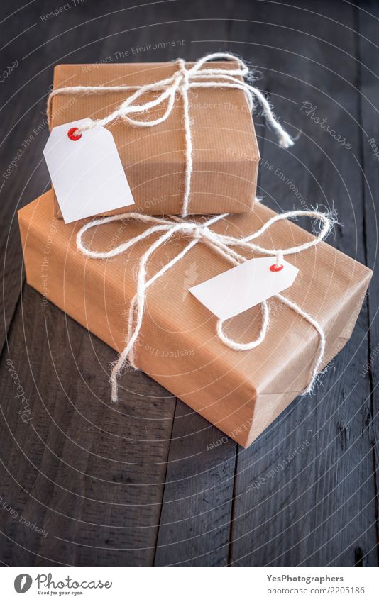 Zwei überlagerte Geschenke mit Etiketten Handarbeit Feste & Feiern Silvester u. Neujahr Geburtstag Paket Schnur Überraschung schwarzer Hintergrund Braunwickel