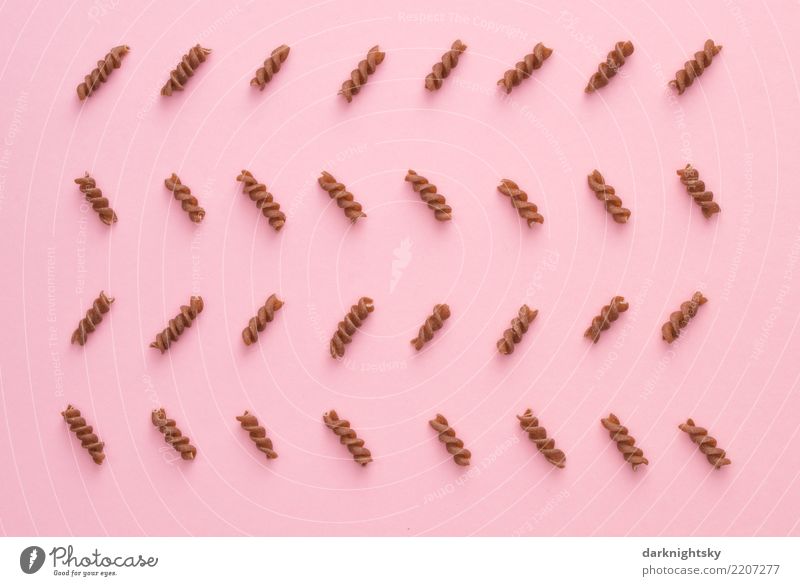 Insgesamt 32 Spirelli Nudeln, auch Spiralen oder in Italien Fusilli genannt, die in einem Zickzack Muster auf einem rosafarbenen Hintergrund arrangiert wurden. Ernährung auf italienisch und geordnete Anordnung auf "deutsche" Art.