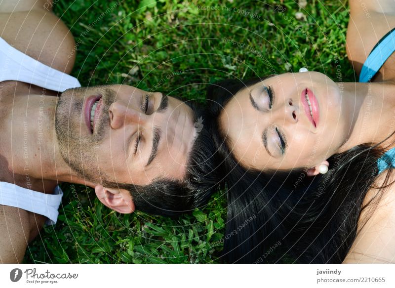 Glückliche lächelnde Paare, die auf grünes Gras legen Lifestyle Freude schön Erholung Freizeit & Hobby Sommer Valentinstag Mensch Frau Erwachsene Mann