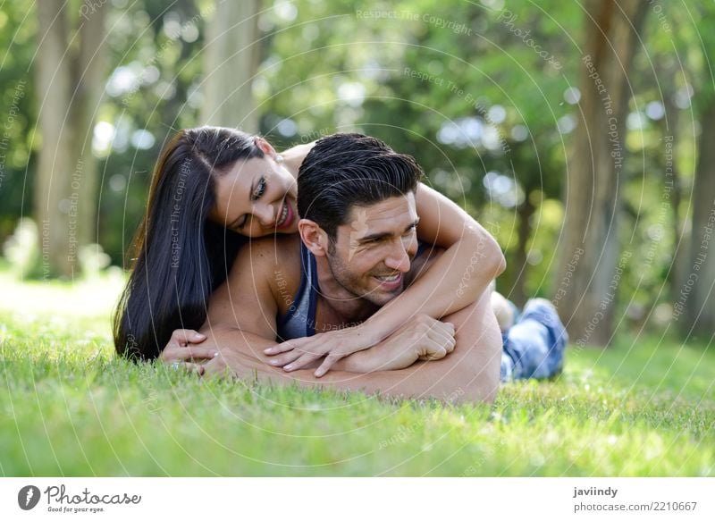 Glückliche lächelnde Paare, die auf grünes Gras legen Lifestyle Freude schön Erholung Freizeit & Hobby Sommer Valentinstag Frau Erwachsene Mann