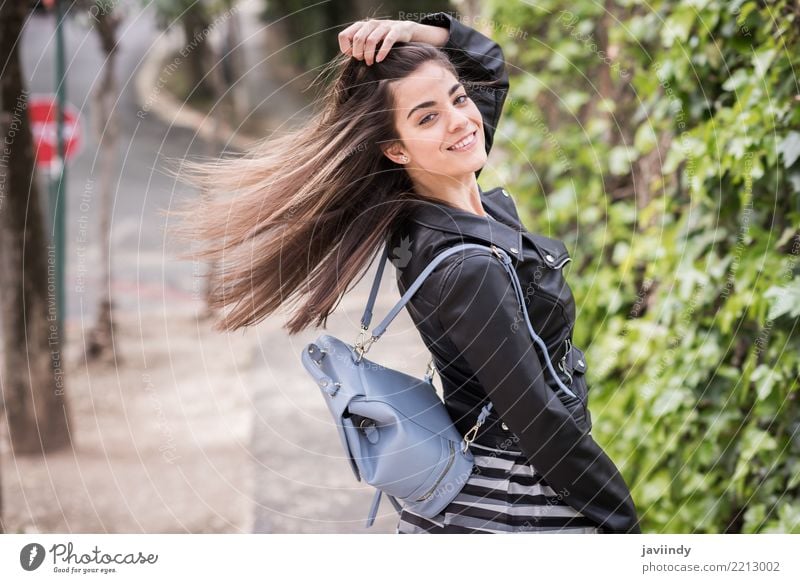 Junge Frau, die ihr Haar im städtischen Hintergrund bewegt Lifestyle Stil Glück schön Haare & Frisuren Mensch Erwachsene Wind Straße Mode Rock Jacke Leder