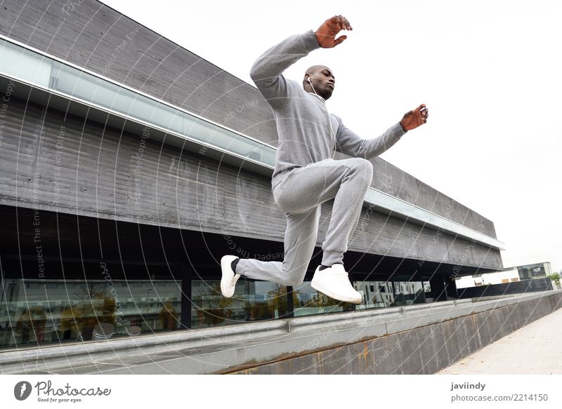 Ein schwarzer Mann, der im urbanen Hintergrund springt. Lifestyle Sport Joggen Mensch Erwachsene Straße Fitness springen rennen Afrikanisch Bewegung weitergeben