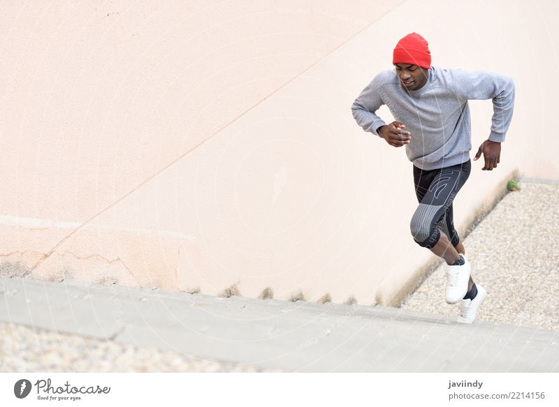 Schwarzer Mann rennt die Treppe hinauf ins Freie. Lifestyle Körper Winter Sport Joggen Mensch Erwachsene Fitness muskulös schwarz Kraft rennen nach oben