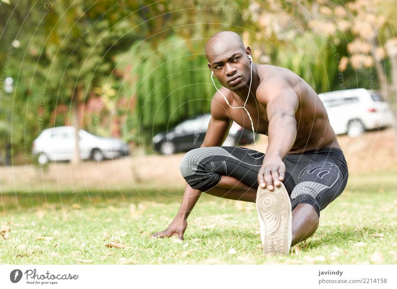 Junger schwarzer Mann, der sich nach dem Laufen im Stadtpark ausdehnt. Lifestyle Körper Sport Mensch maskulin Erwachsene 1 18-30 Jahre Jugendliche Fitness