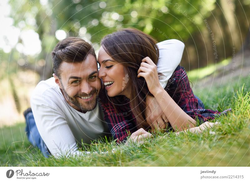 Schöne junge Paare, die auf Gras in einem städtischen Park legen. Lifestyle Freude Glück schön Sommer Mensch maskulin feminin Frau Erwachsene Mann 2 18-30 Jahre