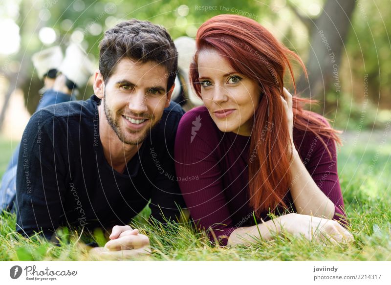 Schöne junge Paare, die auf Gras in einem städtischen Park legen. Lifestyle Freude Glück schön Sommer Mensch maskulin feminin Frau Erwachsene Mann 2 18-30 Jahre