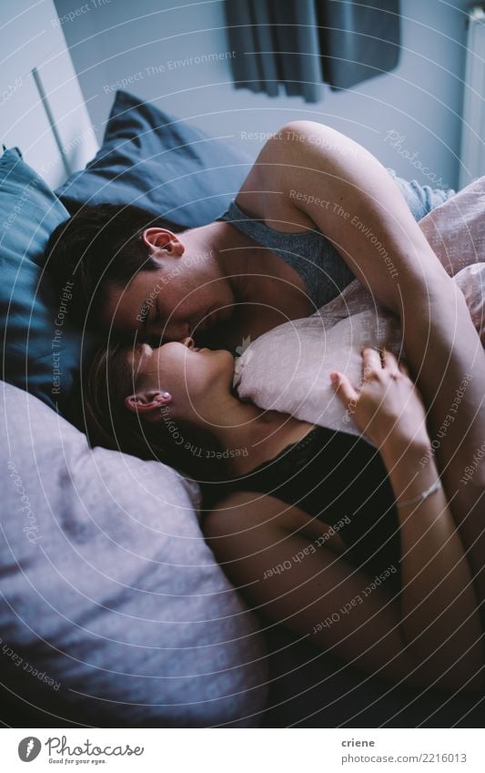 Glückliche junge erwachsene Paare, die einander im Bett betrachten Freude Erholung Winter Haus Schlafzimmer Frau Erwachsene Mann Jugendliche Herbst Küssen