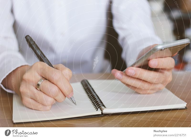 Frauenhände unter Verwendung des Smartphone und Schreiben des Notizbuches Arbeit & Erwerbstätigkeit Büro Business Telefon Handy PDA Bildschirm Internet
