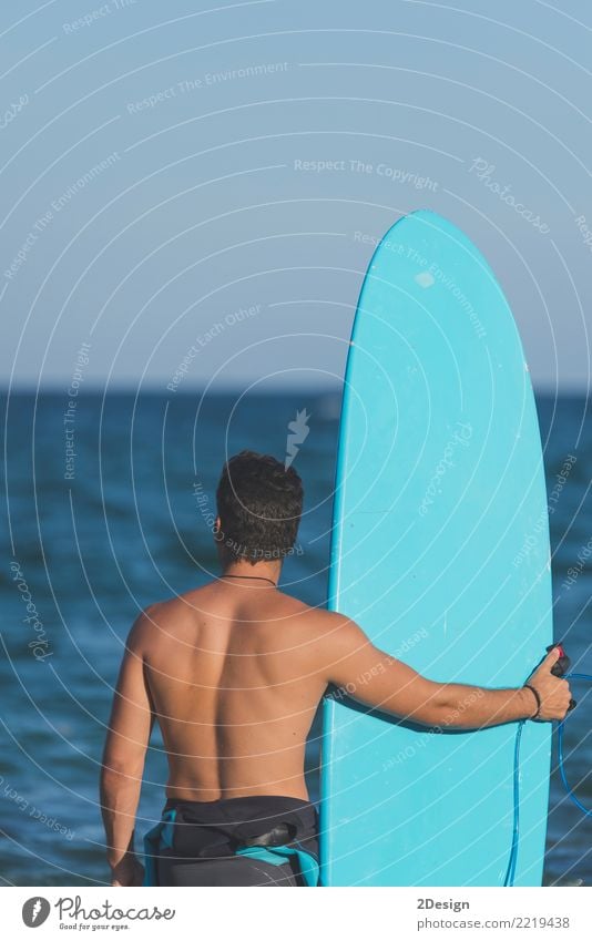 Surfer, der sein Surfbrett am Strand hält Lifestyle Freude Ferien & Urlaub & Reisen Sommer Meer Wellen Sport Mann Erwachsene Jugendliche Himmel Wolken Küste