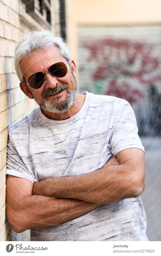 Reifer Mann, der an der Kamera im städtischen Hintergrund lächelt Lifestyle Glück Mensch Erwachsene Männlicher Senior 45-60 Jahre Straße Bekleidung Sonnenbrille