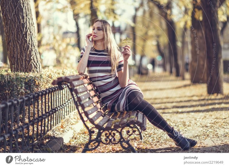 Junge blonde Frau, die auf einer Bank in der Straße sitzt Lifestyle elegant Stil schön Haare & Frisuren Mensch feminin Junge Frau Jugendliche Erwachsene 1