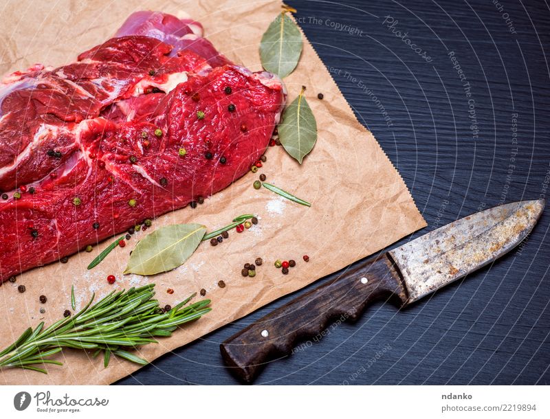 frisches Stück Rindfleisch Fleisch Kräuter & Gewürze Abendessen Messer Tisch Papier Holz Essen natürlich grün rot schwarz Blut hacken geschnitten Feinschmecker