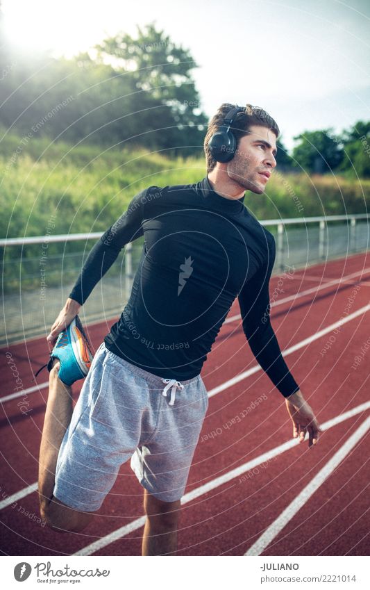 Junger Mann beim Stretching auf der Laufstrecke mit Kopfhörern Trinkwasser Lifestyle Freude Körper Gesundheit Gesunde Ernährung Gesundheitswesen sportlich
