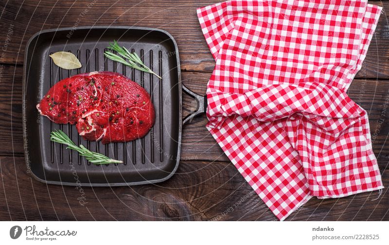 rohes Rindfleisch mit Gewürzen Fleisch Kräuter & Gewürze Abendessen Pfanne Tisch Küche Holz Essen frisch oben braun rot schwarz Hintergrund Barbecue Beefsteak