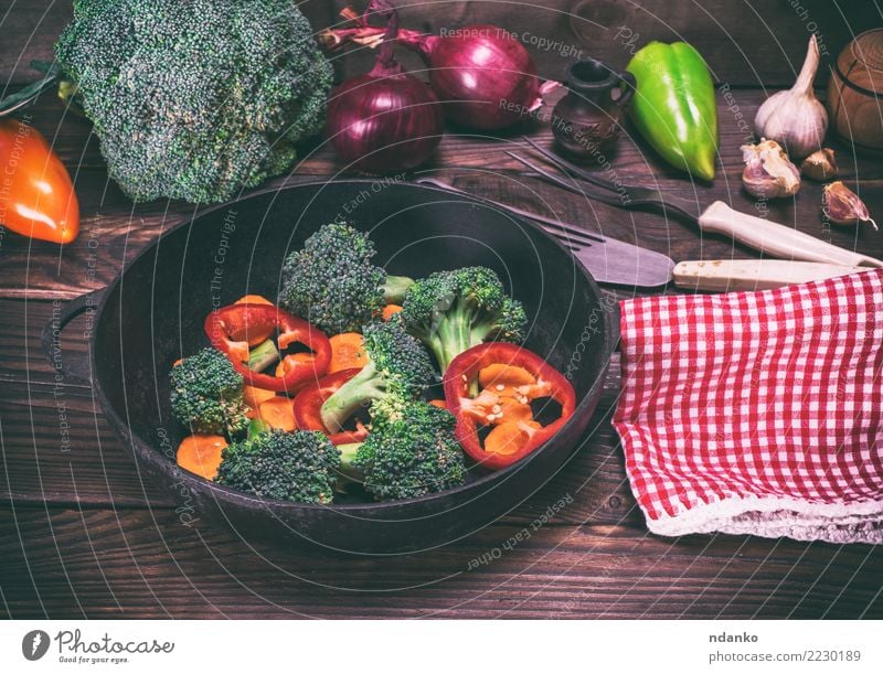Gemüse in einer schwarzen runden Pfanne Ernährung Essen Vegetarische Ernährung Diät Gabel Tisch Küche Natur Pflanze Holz frisch natürlich braun grün rot