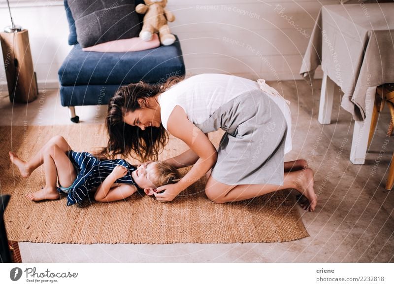 Glückliche Mutter, die zu Hause ihren netten Kleinkindsohn kitzelt Lifestyle Freude Spielen Wohnzimmer Küche Kind Mensch Eltern Erwachsene Lächeln lachen Liebe