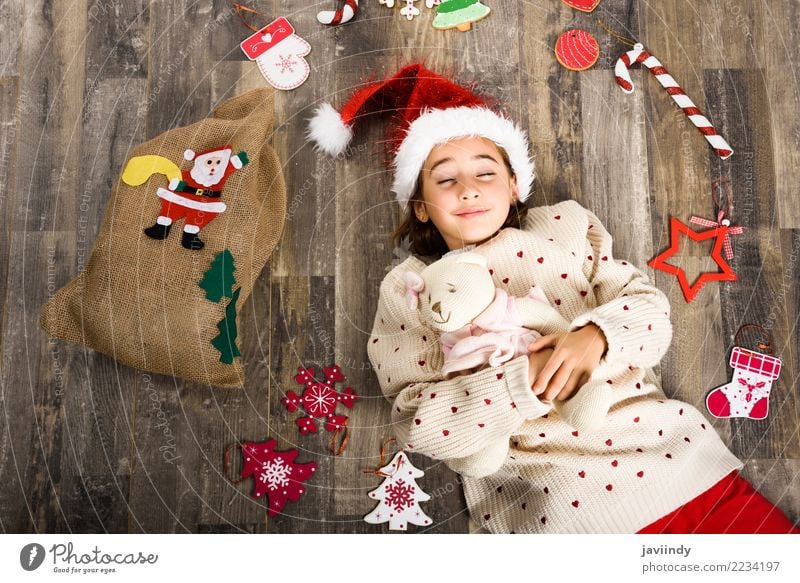 Kleines Mädchen, das den Sankt-Hut schläft auf Bretterboden trägt Glück schön Dekoration & Verzierung Weihnachten & Advent Kind Frau Erwachsene Kindheit 1