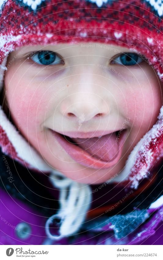 So schmeckt der Winter Mensch Kind Mädchen Kindheit Gesicht Zunge 1 3-8 Jahre Mütze frieren kalt mehrfarbig Lebensfreude Farbfoto Außenaufnahme Nahaufnahme
