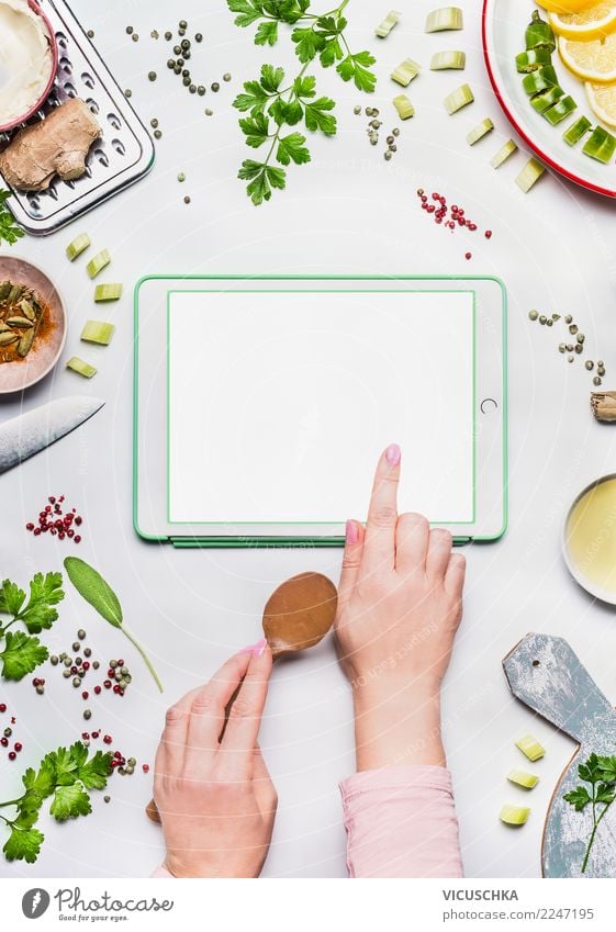 Weibliche Hände mit Tablet PC auf dem Küchentisch Lebensmittel Ernährung Bioprodukte Vegetarische Ernährung Diät Geschirr Stil Design Gesundheit