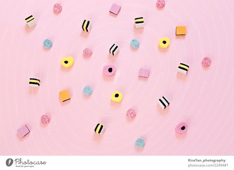 Farbige Süßigkeit zerstreut auf den rosa Hintergrund Dessert Süßwaren Essen Freude Party Feste & Feiern Menschengruppe außergewöhnlich hell lecker blau gelb