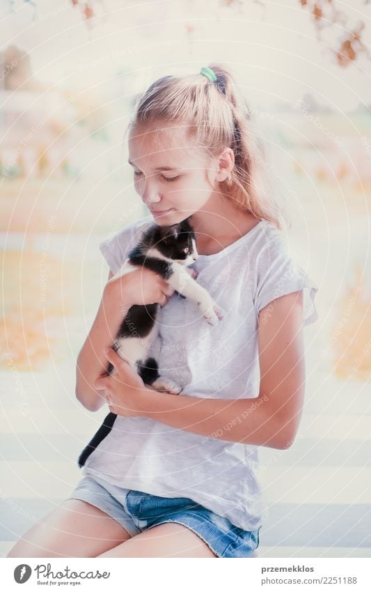 Junges hübsches Mädchen hockt auf der Veranda und umarmt ihre kleine Katze Lifestyle Glück Sommer Sonne Sonnenbad Mensch Junge Frau Jugendliche Erwachsene