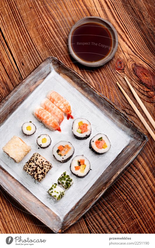 Sushi stellten auf Tonwarenplatte mit Essstäbchen und Sojasoße ein Lebensmittel Meeresfrüchte Mittagessen Teller Tisch Holz Rost frisch lecker oben Tradition