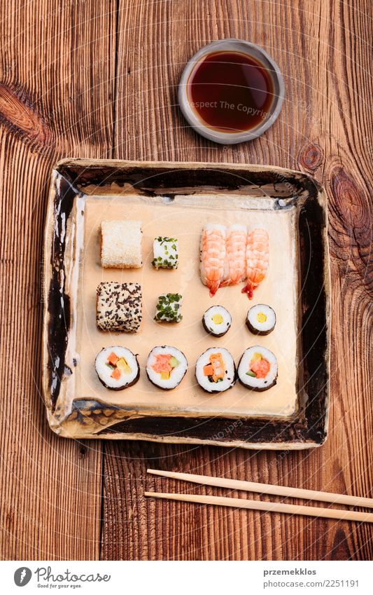 Sushi stellten auf Tonwarenplatte mit Essstäbchen und Sojasoße ein Lebensmittel Meeresfrüchte Mittagessen Teller Tisch Holz Rost frisch lecker oben Tradition