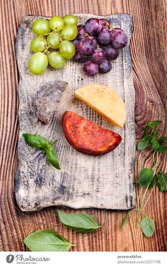 Käse und Trauben, die auf handgemachter Tonwarenplatte verziert werden Lebensmittel Frucht Ernährung Frühstück Mittagessen Teller Tisch Holz Rost frisch lecker