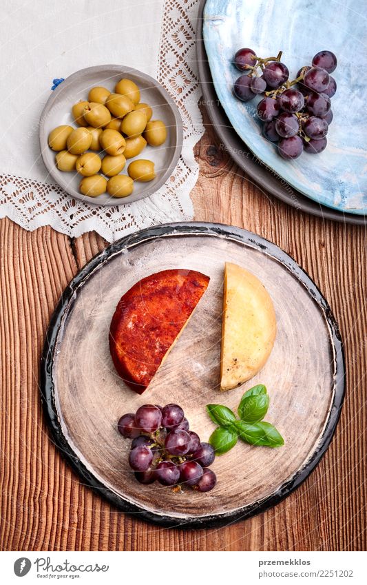 Käse und schwarze Trauben auf handgemachter Tonwarenplatte Lebensmittel Frucht Ernährung Frühstück Teller Tisch Holz Rost frisch lecker oben Keramik