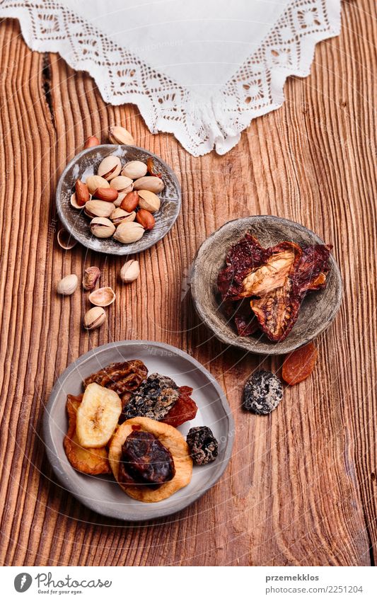 Trockenfrüchte und Nüsse in handgemachten Tonwarenschüsseln Lebensmittel Frucht Dessert Schalen & Schüsseln Tisch Holz Rost lecker oben Keramik getrocknet