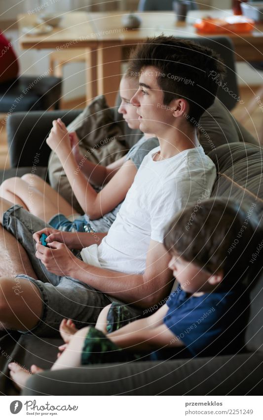 Konzentrierte Jungen und Mädchen, die zu Hause auf dem Sofa sitzend Videospiele spielen Lifestyle Freude Freizeit & Hobby Spielen Kind Technik & Technologie