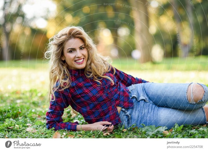 Frau, die auf dem Gras eines städtischen Parks lächelt Lifestyle Freude Glück schön Haare & Frisuren Erholung Mensch feminin Junge Frau Jugendliche Erwachsene 1