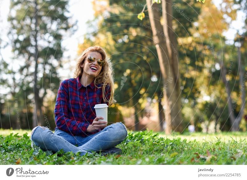Trinkender Kaffee des blonden Mädchens im Park, der auf Gras sitzt Tee Lifestyle Freude Glück schön Haare & Frisuren Erholung Mensch feminin Junge Frau