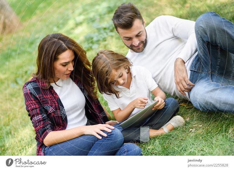 Glückliche Familie in einem städtischen Park beim Spielen mit einem Tablet-Computer Lifestyle Freude schön Sommer Kind Technik & Technologie Mensch Mädchen