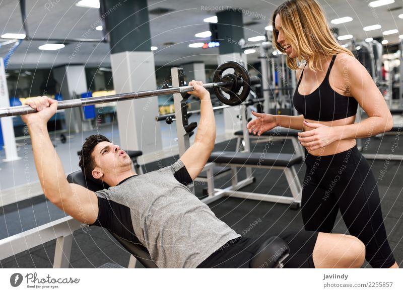 Weiblicher persönlicher Trainer, der Gewichte eines jungen Mannes anhebt Lifestyle Körper Sport Mensch maskulin feminin Junge Frau Jugendliche Junger Mann