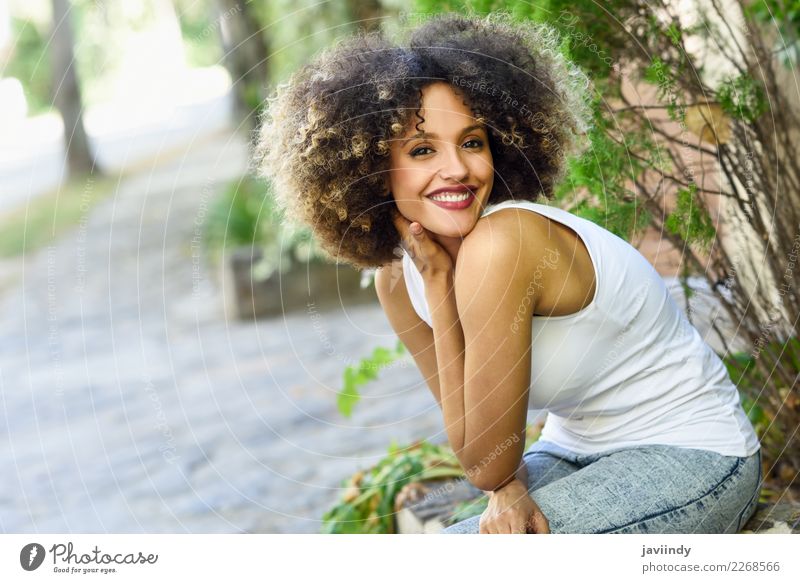 Gemischte Frau mit Afro-Frisur lächelnd im Stadtpark Lifestyle Stil Glück schön Haare & Frisuren Gesicht Mensch feminin Junge Frau Jugendliche Erwachsene 1